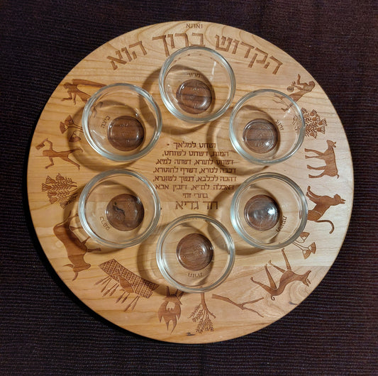 Cherry wood seder plate decorated with images and text of the song Chad Gadyah in Hebrew.