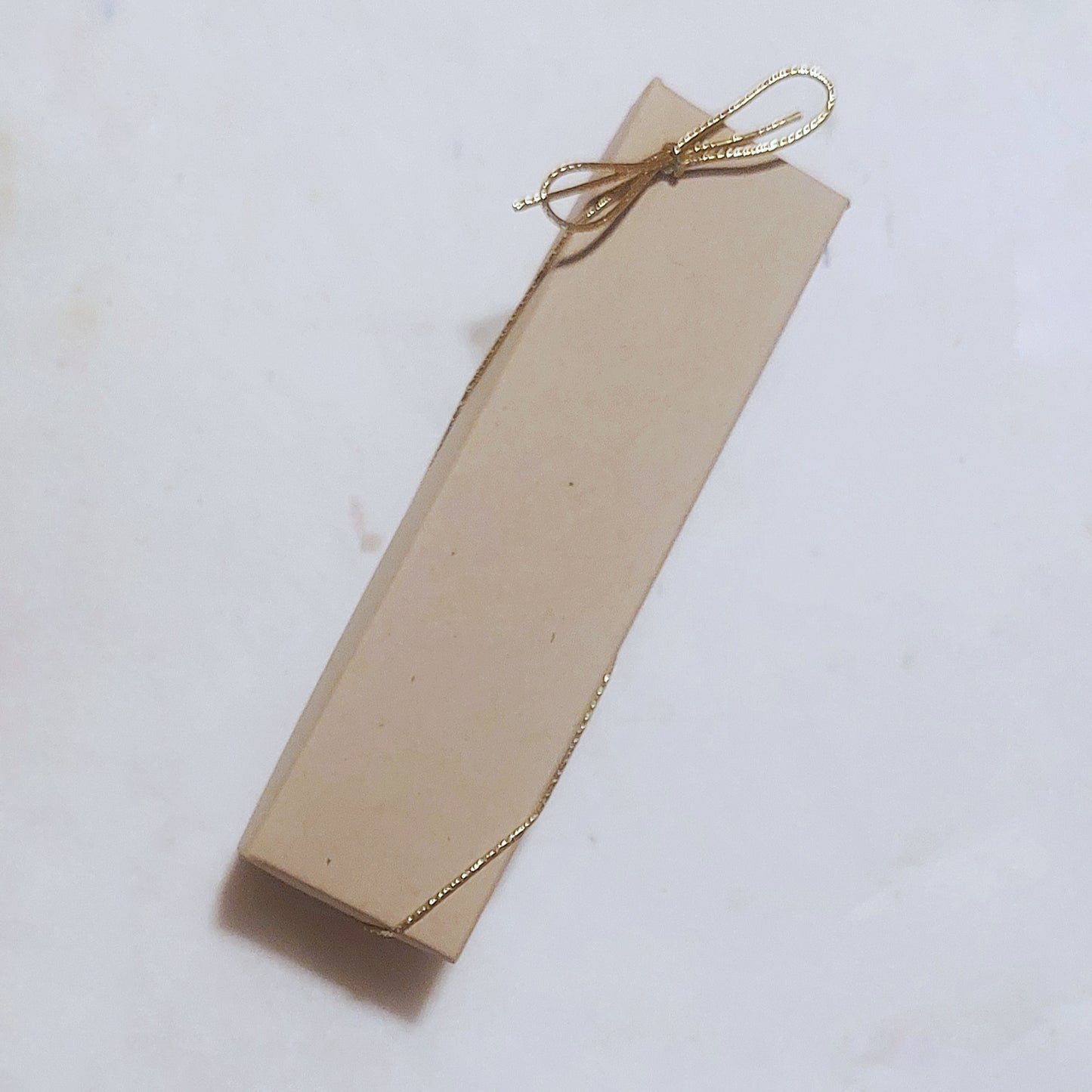 Brown gift box with gold elastic bow
