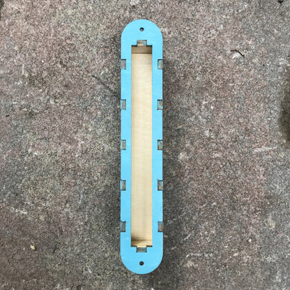 bottom view of blue painted mezuzah case. The bottom has a rectangle hole for the scroll to be placed in.