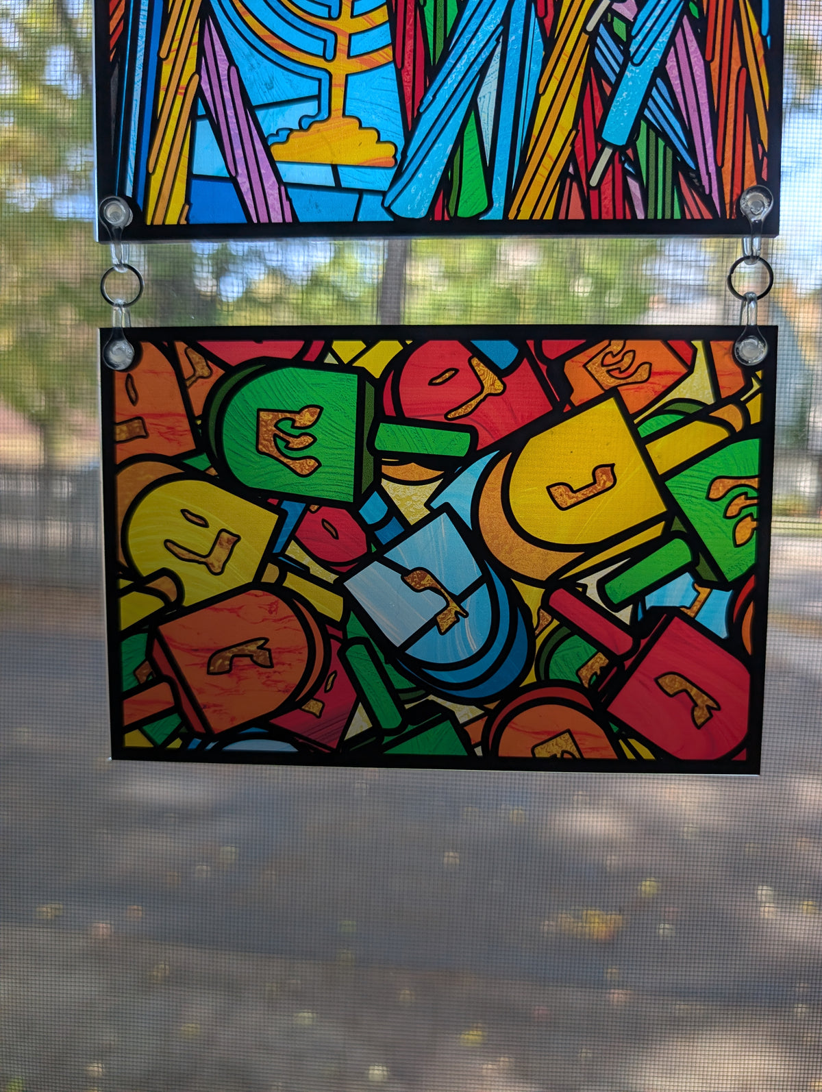 Stained glass style illustration with a pile of dreidels